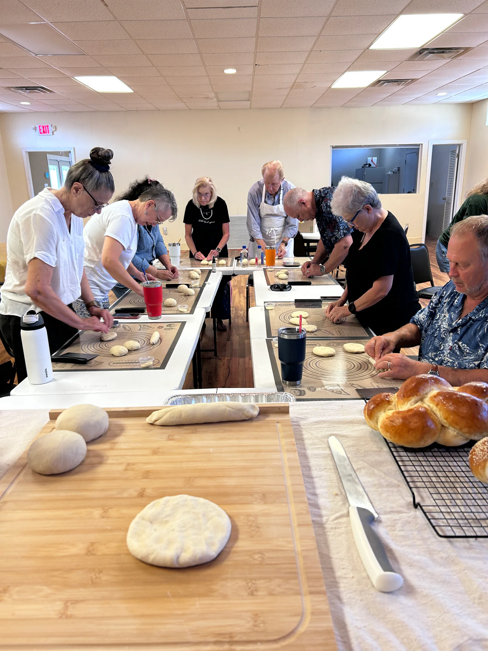 Guests shaping dough in a challah workshop